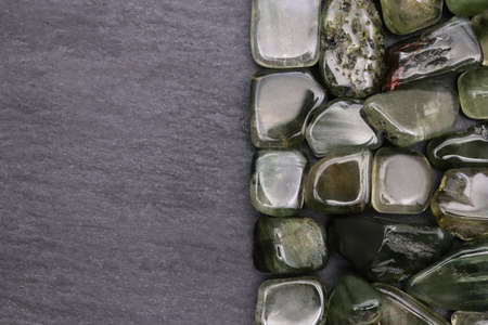 Green rutilated heap jewel stones texture on half white light isolated background. Place for text.の写真素材