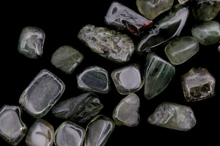 Green rutilated heap jewel stones texture on half white light isolated background. Place for text.の写真素材