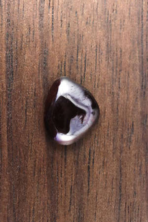Garnet rare jewel stones texture on brown varnished wood background