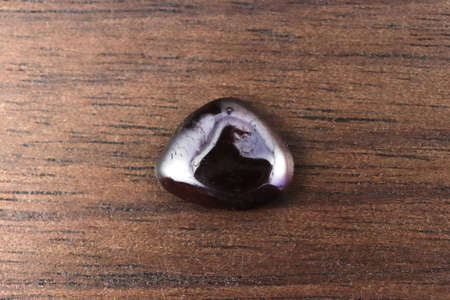 Garnet rare jewel stones texture on brown varnished wood background