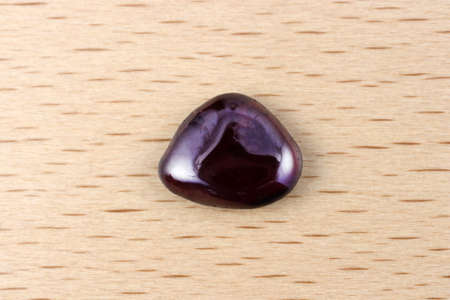 Garnet rare jewel stones texture on brown varnished wood background