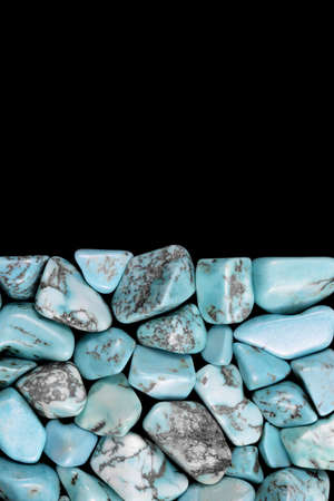 Turquoise heap jewel stones texture on half black background. Place for text.の写真素材