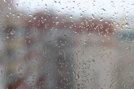 Wet window of cityscape overcast weather. macro closeup