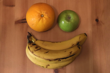 Banana with orange and apple on the tableの写真素材