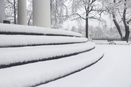 Pavilion under the flag round steps under a thick layer of snow. Landscape of winter park.の写真素材