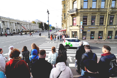 People stand in front of a pedestrian crossing and wait for their traffic lightの写真素材