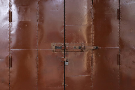 Closed iron gate with shutter and padlock