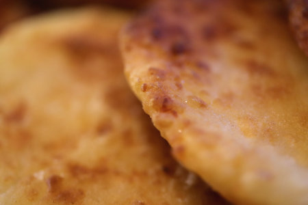 Fresh cottage cheese. Home fried pastries background. Juicy fried cheesecake pancake.