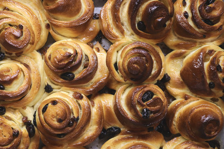 Close-up of freshly baked raisin pastries with golden brown crusts.