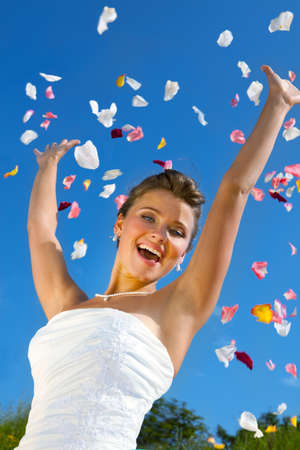 Happy Beautiful Bride and Colorful Petals at the Blue Skyの写真素材