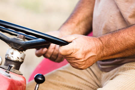 Close Up Of Hands of Harvester Working at the Corn Field with Tractor Steering Wheelの写真素材