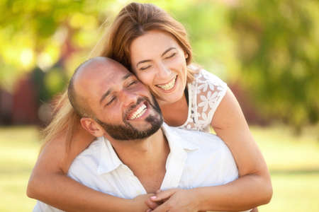 Smiling Young Woman and Young Man are Happy Together - they are Smiling and Embracing in Nature at...