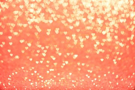 Valentine's Day Concept: Yellow Sparklng Defocused Romantic Hearts on the Red Backgroundの写真素材