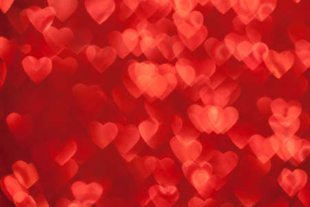 Valentine's Day Concept: Red Sparklng Defocused Romantic Background of Lights Hearts..