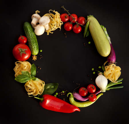 Wreath of Fine Food Products - Fresh Vegetables, Homemade Pasta and Spices on the Black Backgroundの写真素材
