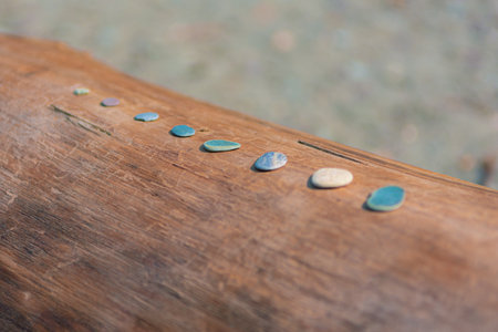 small flat rocks on the wooden beamの写真素材