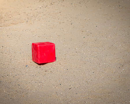 childrens red toy block on a sandの写真素材
