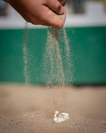 A child fills sand through the fingers on a toyの写真素材