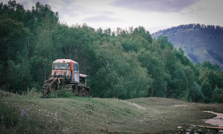 An old crawler tractor in rural landscape colored