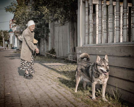 19th of July 2018, Russia, Tomsk, older woman with dog on the streetのeditorial素材