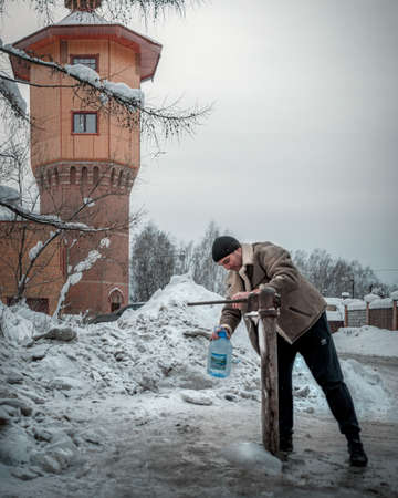 21st of December 2019, Russia, Tomsk, water tower and hand water pumpのeditorial素材
