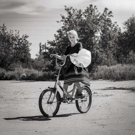 18th of July 2020, Russia, Altay,girl on a bike rural sceneのeditorial素材