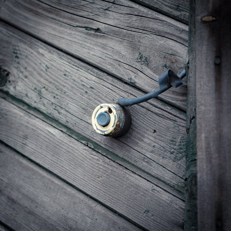 an old doorbell button on the wooden wall