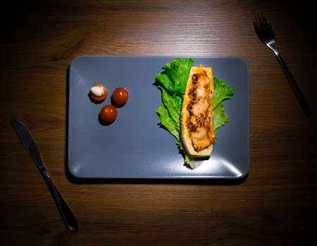 The stuffed zucchini with salad and cherry tomatoes on the quarter plate top viewの写真素材