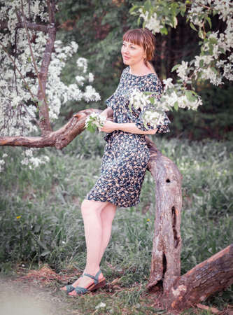 Young woman portrait on the blooming apple trees backgroundの写真素材