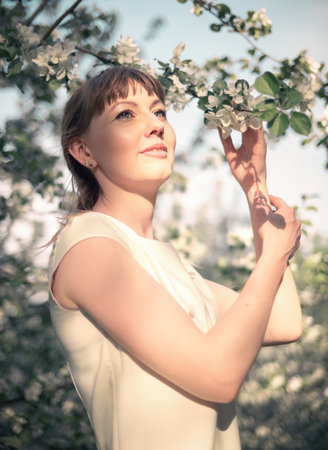 Young woman portrait on the blooming apple trees backgroundの写真素材