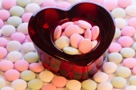 Heart-shaped glass bowl filled with candy for Valentines Day