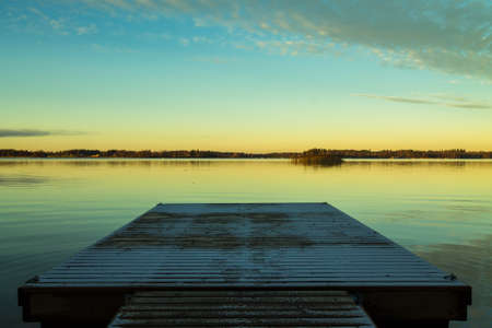 Scandinavian lake in the sunset with a frozen  jettyの写真素材
