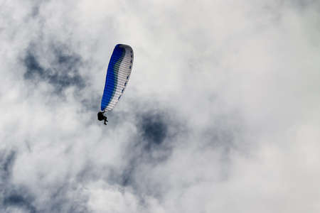 Paragliding against the white cloudsの写真素材