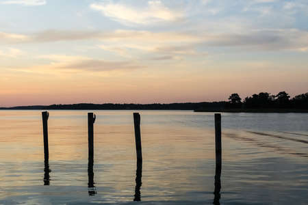 Docking poles in the ocean against the beautiful sunsetの写真素材