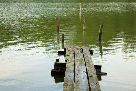 Broken down pier in the green ocean waterの写真素材
