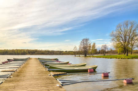 Rowboats tied to a wooden pier in a small harborの写真素材