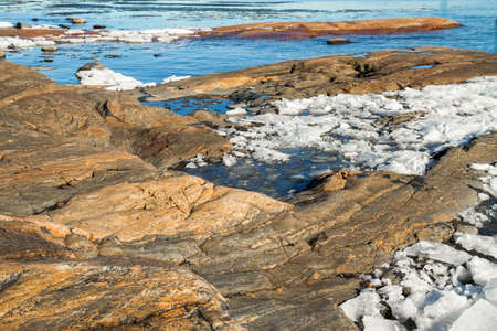 Spring is coming and ice is melting on the rocky shores of the Baltic Seaの写真素材