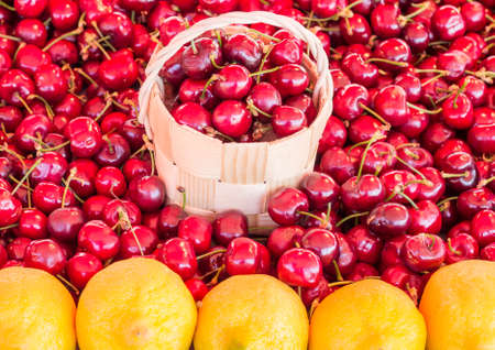 Basket of cherries in a cherry background at the market with lemonsの写真素材