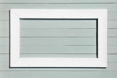 White empty frame on a light blue wooden backgroundの写真素材