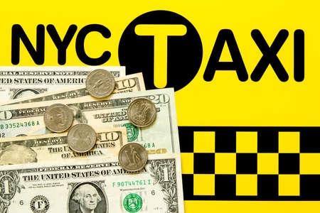 NYC Taxi fare concept - Dollar bills and coins on the black and yellow backgroundの写真素材