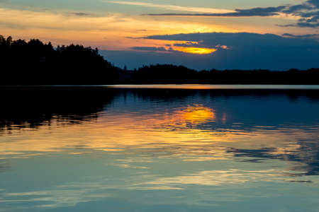 Beautiful sunset reflecting on a lakeの写真素材