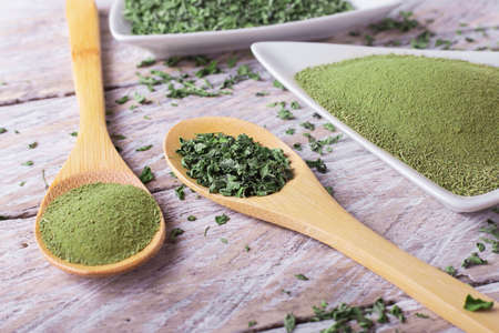 Powder and moringa leaves in bowl on rustic wooden backgroundの写真素材