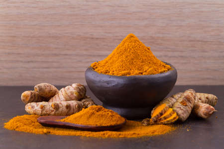 Turmeric powder and rootsの写真素材