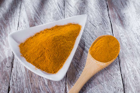Turmeric powder and rootsの写真素材