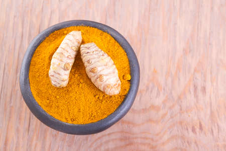 Turmeric powder and rootsの写真素材