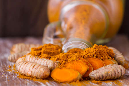 Turmeric powder and rootsの写真素材
