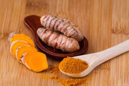 Turmeric powder and rootsの写真素材