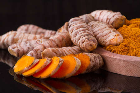 Turmeric powder and rootsの写真素材