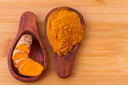 Turmeric powder and rootsの写真素材