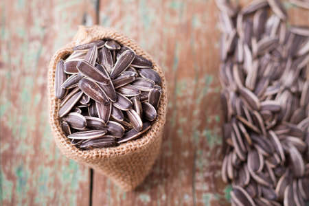 sunflower seeds on the wooden table (Helianthus annuus)の写真素材
